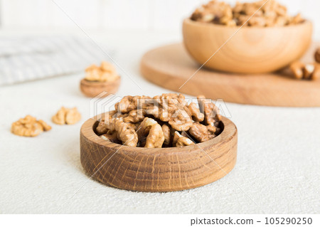 Fresh healthy walnuts in bowl on colored table background. Top view Healthy eating bertholletia concept. Super foods 105290250