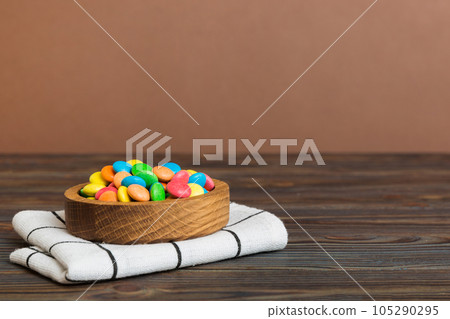 Multicolored candies in a bowl on a colored background. birthday and holiday concept. Top view with copy space Multicolored candies in a bowl on a colored background. birthday and holiday concept. Top view with copy space 105290295