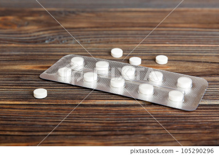 Blister package with aspirin on color background. Medicine pills on a light background. Medicines and prescription pills flat lay background. white medical tablets in blister Blister package with aspirin on color background. Medicine pills on a light background. Medicines and prescription pills flat lay background. white medical tablets in blister 105290296