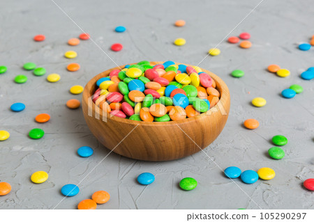Multicolored candies in a bowl on a colored background. birthday and holiday concept. Top view with copy space Multicolored candies in a bowl on a colored background. birthday and holiday concept. Top view with copy space 105290297