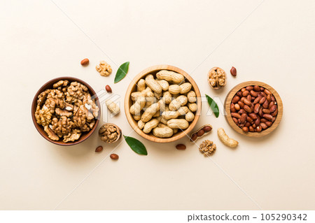 Walnut kernel halves, in a wooden bowl. Close-up, from above on colored background. Healthy eating Walnut concept. Super foods with copy space Walnut kernel halves, in a wooden bowl. Close-up, from above on colored background. Healthy eating Walnut concept. Super foods with copy space 105290342