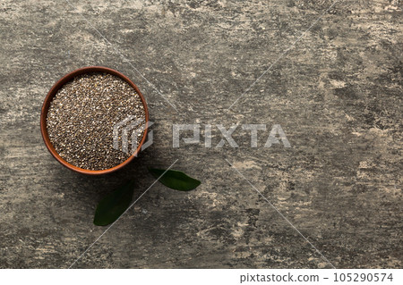 Chia seeds in bowl on colored background. Healthy Salvia hispanica in small bowl. Healthy superfood Chia seeds in bowl on colored background. Healthy Salvia hispanica in small bowl. Healthy superfood 105290574
