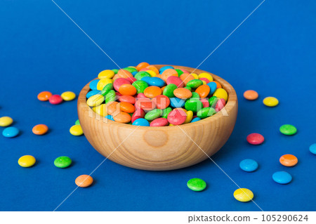 Multicolored candies in a bowl on a colored background. birthday and holiday concept. Top view with copy space 105290624