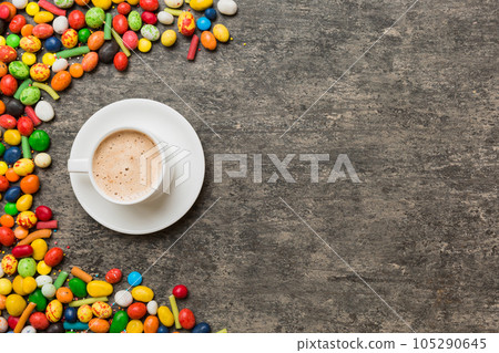 Coffee cup with chocolates and colored candy. Top view on table background with copy space 105290645