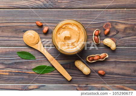 Bowl of peanut butter and peanuts on table background. top view with copy space. Creamy peanut pasta in small bowl Bowl of peanut butter and peanuts on table background. top view with copy space. Creamy peanut pasta in small bowl 105290677