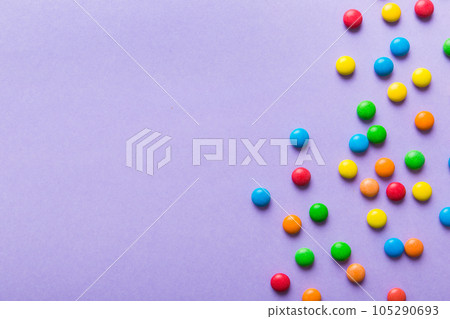 Mixed collection of colorful candy, on colored background. Flat lay, top view. frame of colorful chocolate coated candy 105290693