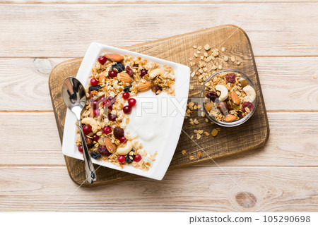 Healthy breakfast food with granola, yogurt, fruits and nuts. Dessert parfait with dried fruits for breakfast 105290698