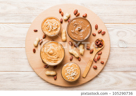 Glass jar with peanut butterin plate on table background, top view space for text and close up Glass jar with peanut butterin plate on table background, top view space for text and close up 105290736