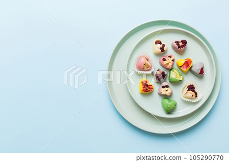 Plate with different chocolate on colored background. Assortment of fine chocolates top view vith copy space Health and obesity concept 105290770
