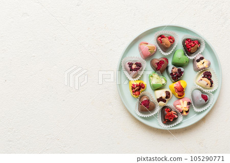 Plate with different chocolate on colored background. Assortment of fine chocolates top view vith copy space Health and obesity concept 105290771