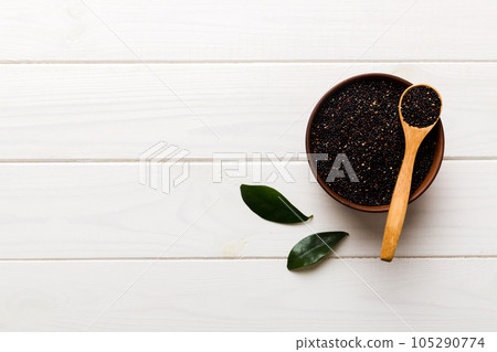 quinoa seeds in bowl and spoon on colored background. Healthy kinwa in small bowl. Healthy superfood quinoa seeds in bowl and spoon on colored background. Healthy kinwa in small bowl. Healthy superfood 105290774