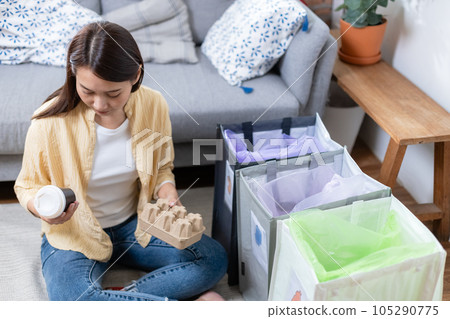 Asian young female sitting at home separating paper and plastic waste. Asian young female sitting at home separating paper and plastic waste. 105290775