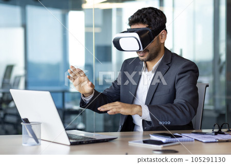 Businessman using vr glasses to view educational material and financial documents, graphs and tables online, financier inside office at workplace. 105291130