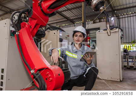 Engineers woman holding tablet to check condition robotic arm. 105291658