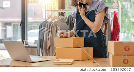 Close up woman designer stylish blogger entrepreneur is write the customer name in front of the box and taking receive online delivery order to prepare packing the product online shopping delivery 105292007