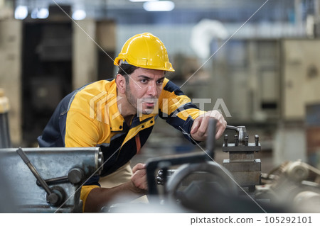 Caucasian man engineering workers wear yellow hard hat working machine lathe metal. Caucasian man engineering workers wear yellow hard hat working machine lathe metal. 105292101