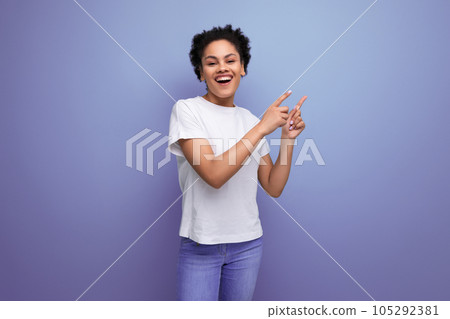 a young brunette woman with afro hair in a white t-shirt demonstrates with inspiration with the help a young brunette woman with afro hair in a white t-shirt demonstrates with inspiration with the help 105292381
