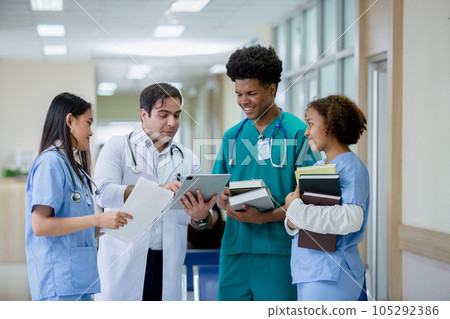 Teacher doctor man and group medical student standing looking work in tablet. 105292386