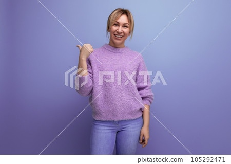 charming cute blondie woman in lavender sweater smiling on purple background with copy space charming cute blondie woman in lavender sweater smiling on purple background with copy space 105292471