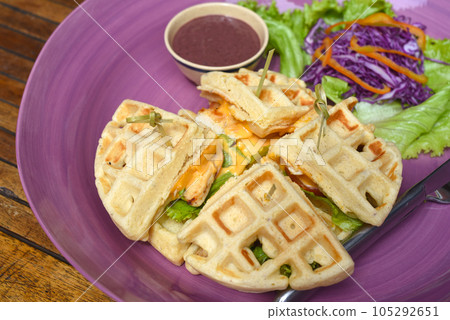 Belgium waffles with pan fried chicken on purple plate Belgium waffles with pan fried chicken on purple plate 105292651