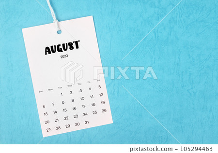 The 2023 August calendar page hanged on white rope on blue background. The 2023 August calendar page hanged on white rope on blue background. 105294463