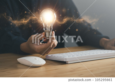 Business man holding light bulb and laptop, keyboard and mouse. New idea, innovation technology and creativity concept. 105295661