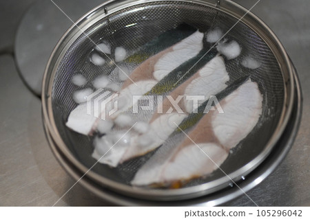 Cooling pre-boiled yellowtail in ice water 105296042