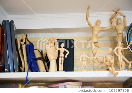 Wooden drawing mannequin dummy, doll to learn how to draw the human body in position of movement, on shelf in art store. Wooden drawing mannequin dummy, doll to learn how to draw the human body in position of movement, on shelf in art store. 105297506