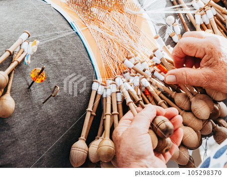 Woman weaves lace with bobbins at workshop close up Woman weaves lace with bobbins at workshop close up 105298370