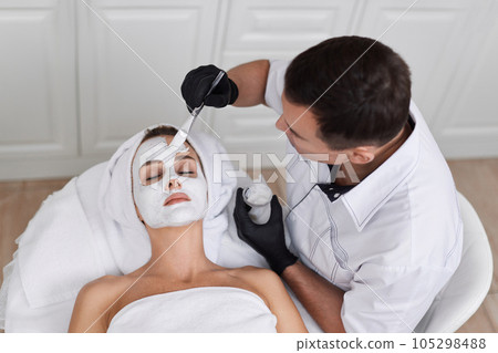 beautician applies the mask to face of woman in the spa salon. skin care 105298488