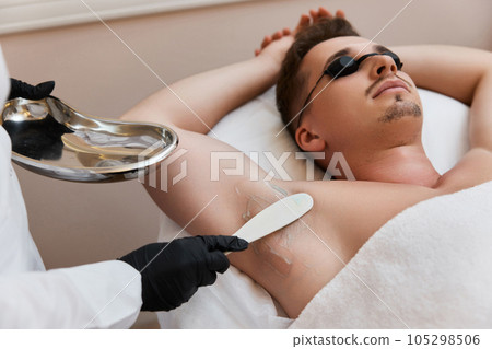young man undergoes procedure of arm pit laser epilation 105298506