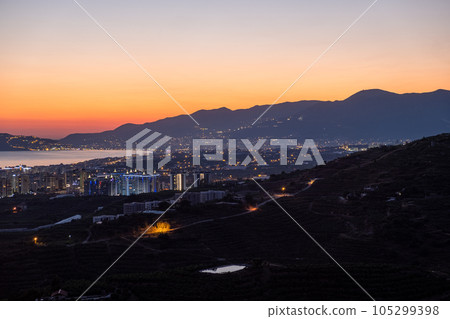 Night city. Alanya, Turkey. Beautiful lights of night city. View of Alanya harbor form Alanya peninsula. Turkish Riviera by night. 105299398