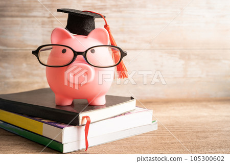 Pigging bank wearing eyeglass with with coins and calculator; saving bank education concept. Pigging bank wearing eyeglass with with coins and calculator; saving bank education concept. 105300602