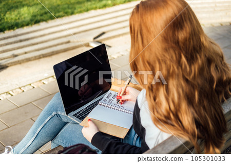 Personal Life Goals for Students. Successful students have goals. Succeeding in college and in life. Outdoor portrait of redhead student girl with laptop and backpack in city park Personal Life Goals for Students. Successful students have goals. Succeeding in college and in life. Outdoor portrait of redhead student girl with laptop and backpack in city park 105301033