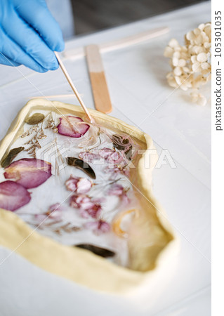 Side hustle, Money-Making Crafts, DIY Crafts To Create and Make Money. Epoxy Resin Art. Creating Art with Resin on workshop. The art process of creating epoxy resin handmade staff in art studio. 105301035