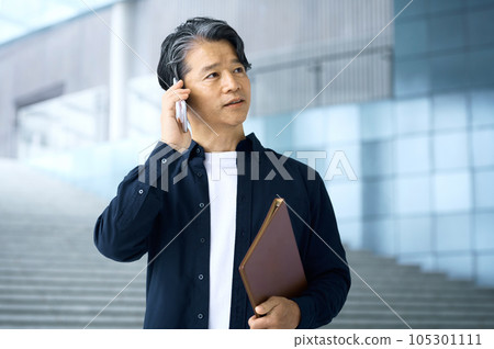 Plainclothes businessman making a phone call in the office Plainclothes businessman making a phone call in the office 105301111