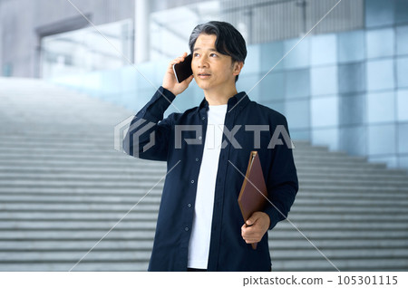Plainclothes businessman making a phone call in the office 105301115