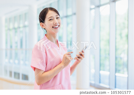 A female medical worker who operates a smartphone 105301577