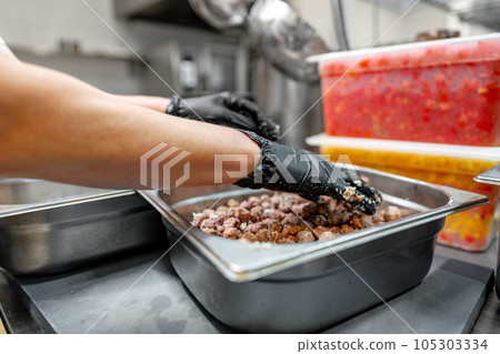 Chef cooking food at restaurant kitchen close up Chef cooking food at restaurant kitchen close up 105303334