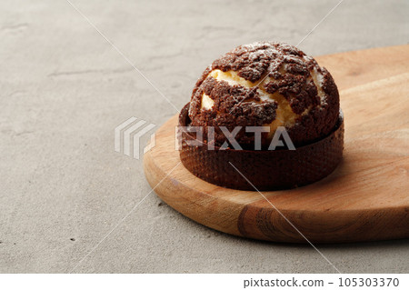 Choux pastry with cracked chocolate crumble topping 105303370