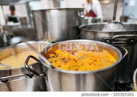 Food preparing in metal pots on the stove at professional kitchen Food preparing in metal pots on the stove at professional kitchen 105303383