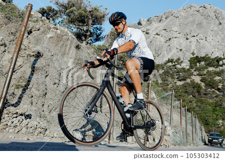 Professional road bicycle racer in action on mountain road 105303412