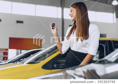 Young attractive woman buying a new car in car salon 105303748