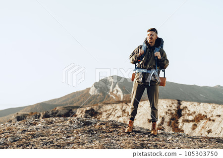 Young caucasian man traveler with big backpack hiking in the mountains 105303750