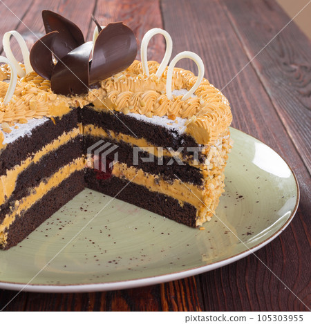 Cut caramel cake on plate on wooden table Cut caramel cake on plate on wooden table 105303955