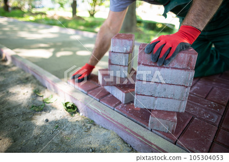 Paving work for laying a new pedestrian path is being done in the summer. 105304053