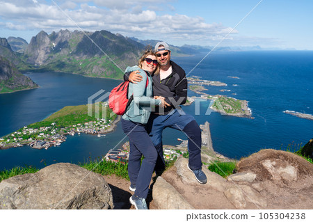 Happy Hiking couple enjoying Norway fjord view. Happy couple relax on top of Reinebringen, fjord. 105304238