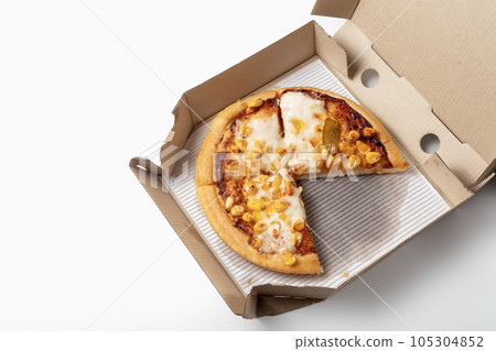 Corn pizza in a cardboard open delivery box on a white background. A piece is missing from the box. Top view. 105304852