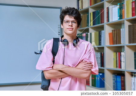Portrait of confident guy college student looking at camera inside library 105305057
