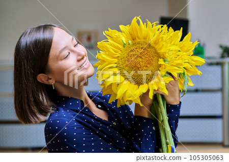 Young happy woman with bouquet of yellow sunflower Young happy woman with bouquet of yellow sunflower 105305063